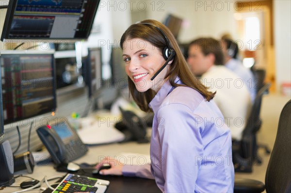 Portrait of female trader at trading desk.