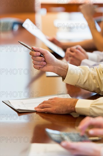Hands of business people at business meeting.