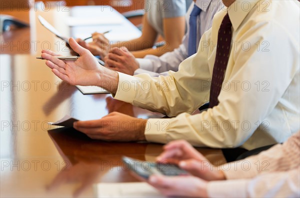 Hands of business people at business meeting.