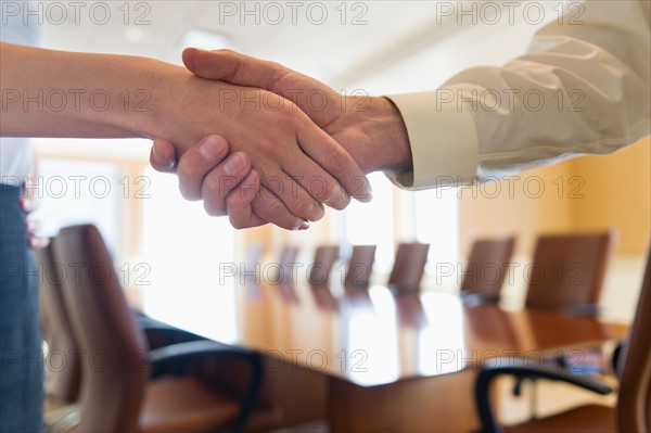 Close-up of business man and woman shaking hands.