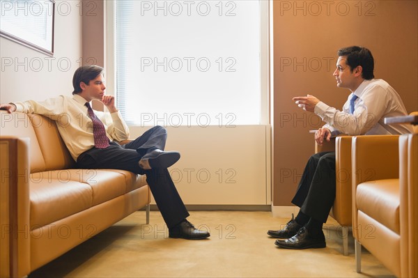 Two businessmen talking in office.