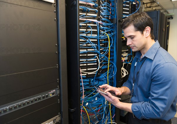 Technician inspecting network server.