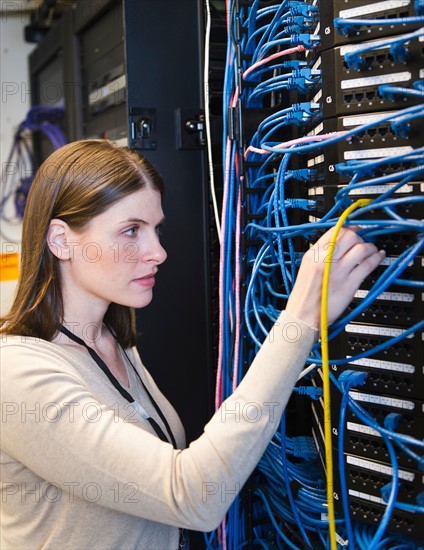 Female IT support technician repairing server.