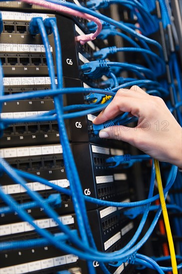 Close-up of female IT support technician repairing server.