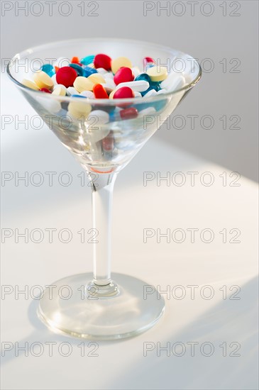 Martini glass filled with pills, studio shot.