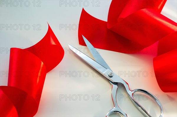 Scissors and red ribbon, studio shot.