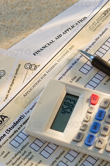 Studio shot of application form and calculator.