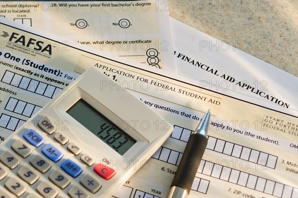 Studio shot of application form and calculator.