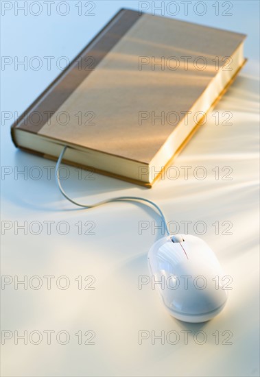 Studio shot of book with computer mouse.