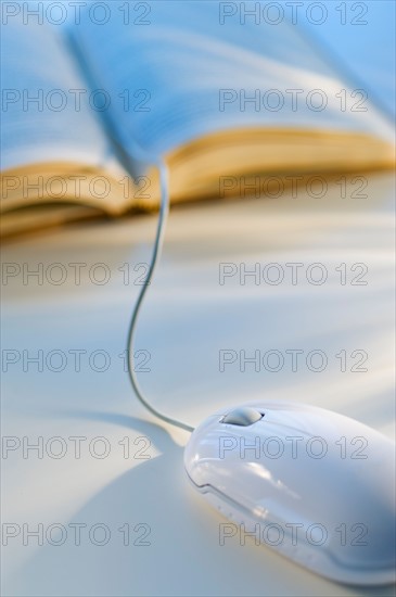 Studio shot of book with computer mouse.