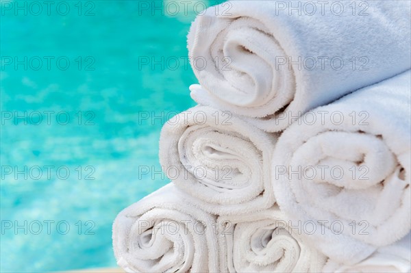 Rolled up towels in front of water.