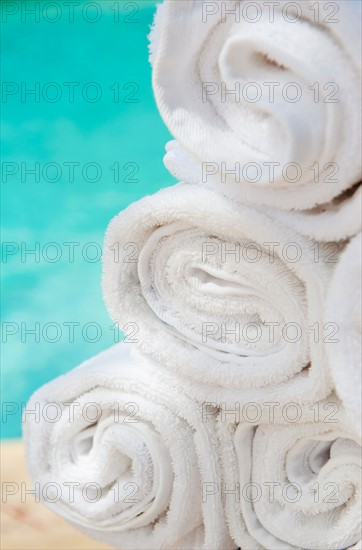 Rolled up towels in front of water.