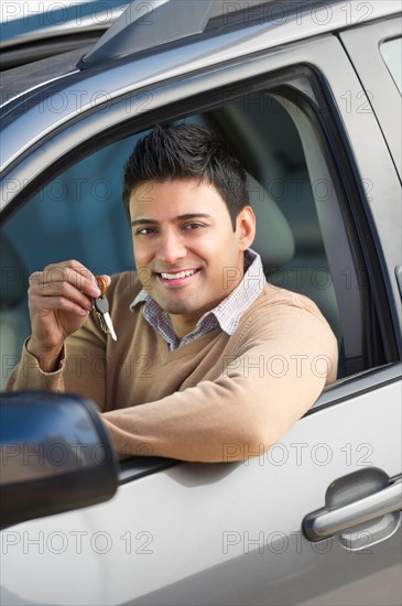 Man sitting in his new car.
