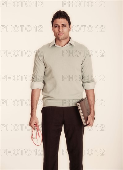 Woman holding laptop and computer cable.