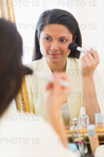 Woman applying blush.