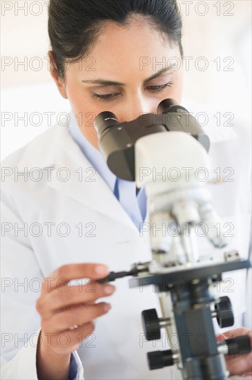 Scientist looking through microscope.