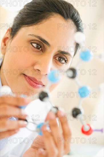 Scientist holding molecular model.