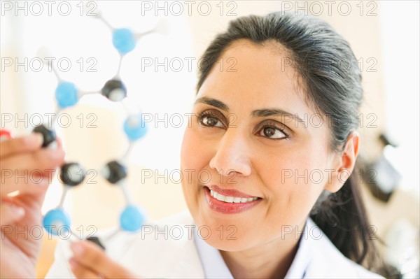 Scientist holding molecular model.