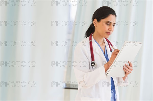 Doctor filling medical document.