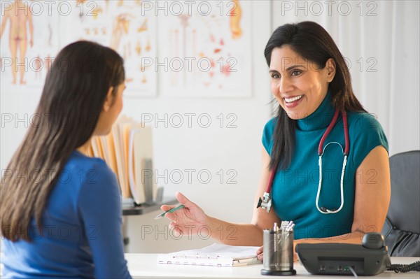 Doctor and patient (12-13) in doctor's office.