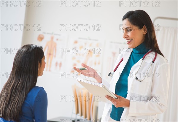 Doctor and patient (12-13) in doctor's office.