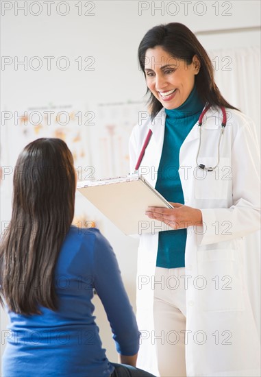 Doctor and patient (12-13) in doctor's office.