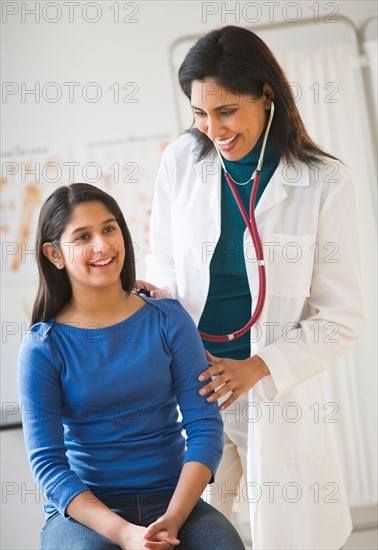 Doctor examining girl (12-13).