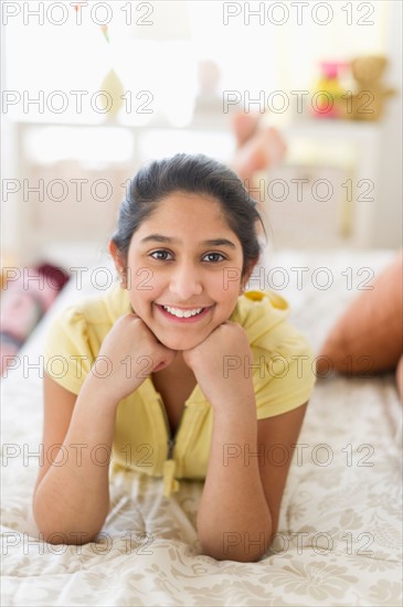 Portrait of girl (12-13) lying on bed.