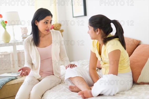 Mother and daughter (12-13) talking at home.