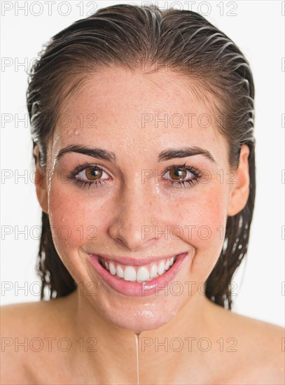 Studio portrait of woman with wet face.