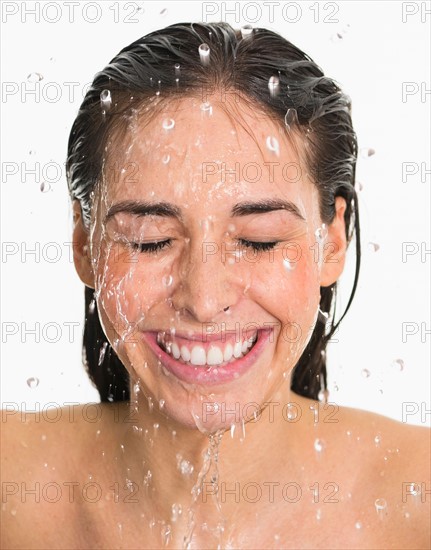 Studio shot of woman with splash of water on face.