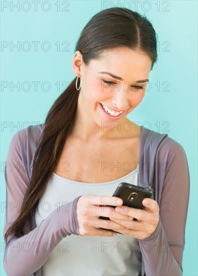 Studio shot of woman using smart phone.