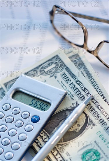 Calculator, pen and banknotes.