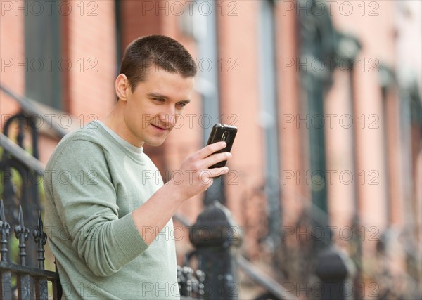 Man using smart phone on street.