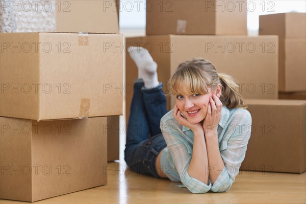 Woman lying among cardboard boxes during relocation.