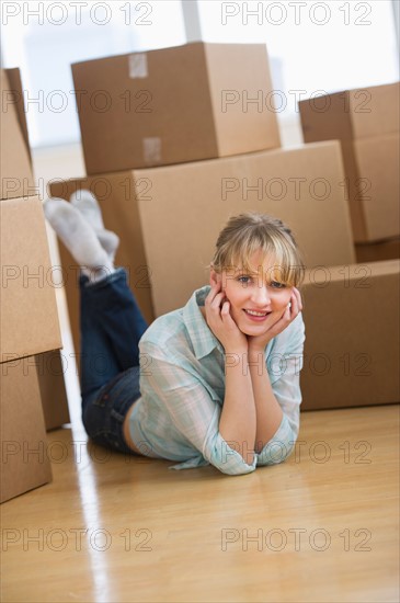 Woman lying among cardboard boxes during relocation.