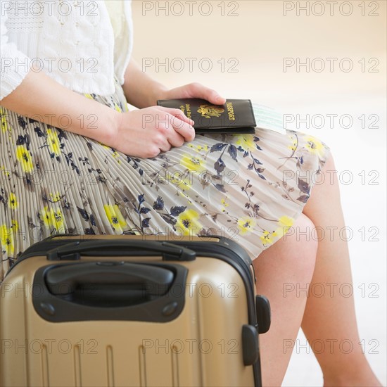 Close up of woman with luggage and passports.