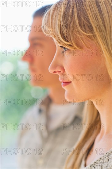 Close up woman's profile with man in background.