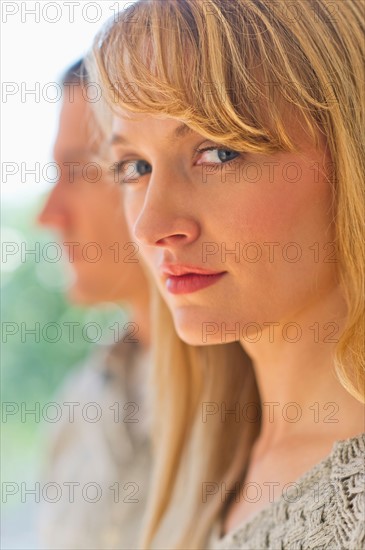 Close up woman's face with man in background.