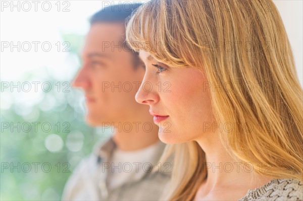 Close up woman's profile with man in background.