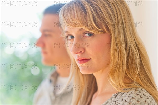 Close up woman's face with man in background.