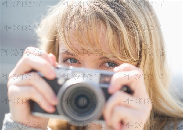 Portrait of smiling woman with camera.