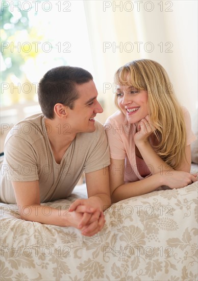 Couple lying on bed .