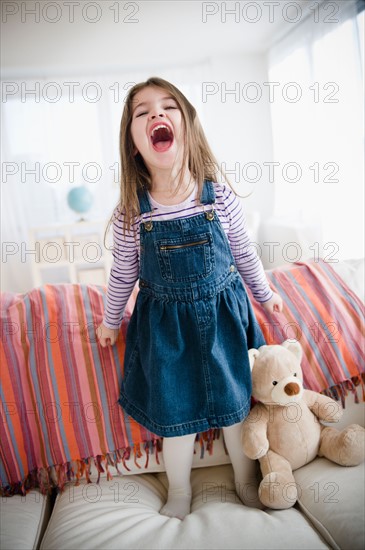 Small girl  (4-5 years) standing on sofa. Photo : Jamie Grill