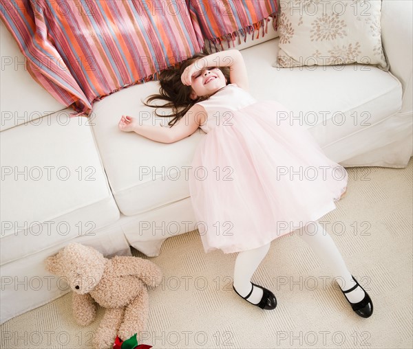 Small girl (4-5 years) in tulle dress leaning on sofa. Photo : Jamie Grill