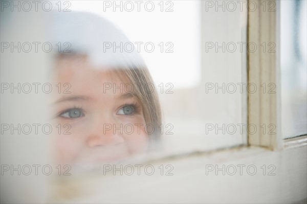 Small girl  (4-5 years) looking through window. Photo : Jamie Grill