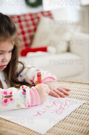 Portrait of small girl  (4-5 years) writing letter to Santa Claus. Photo : Jamie Grill