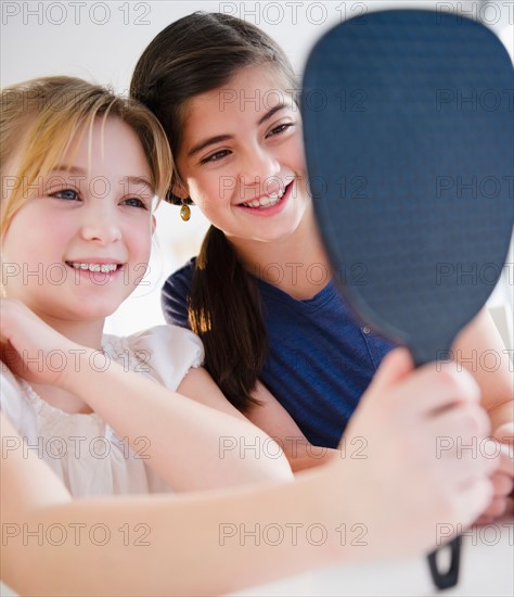 Two girls looking at mirror. Photo : Jamie Grill