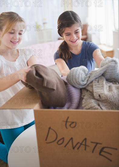 Two girls packing clothing for donations. Photo : Jamie Grill