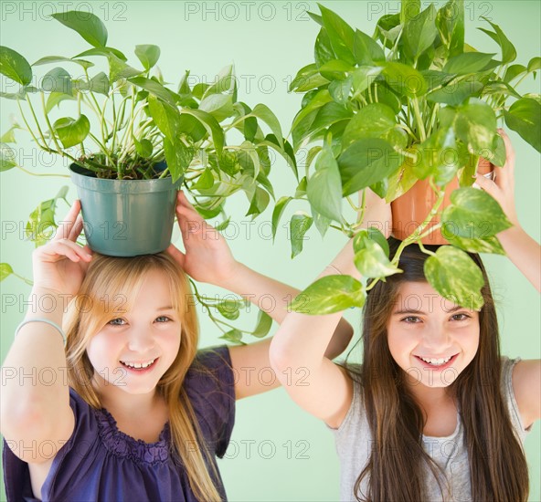 Two girls carrying potted plants on heads. Photo : Jamie Grill